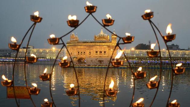 Sikh devotees pay respect on the occasion of the birth anniversary of the fourth Sikh Guru Ramdas at the illuminated Golden Temple in Amritsar on October 15. (Narinder Nanu / AFP)