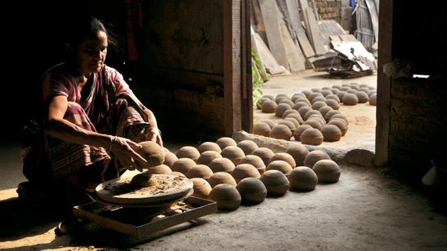 A woman makes earthen lamps for the upcoming Diwali festival in Jammu city, Jammu and Kashmir. (Nitin Kanotra / HT Photo)