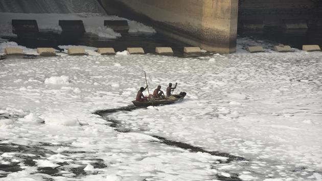 Local fishermen row their boat at the Yamuna river that is covered by froth from discharge of untreated industrial and domestic waste, in Noida, Uttar Pradesh. (Virendra Singh Gosain / HT Photo)