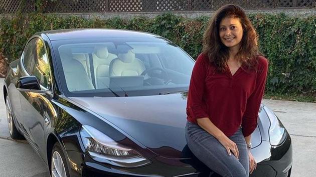 Pooja Batra poses with her new car, a Tesla Model 3.