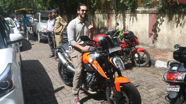 John Abraham arrived to vote on a bike.