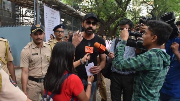 Bobby Deol talks to the media at a polling station.