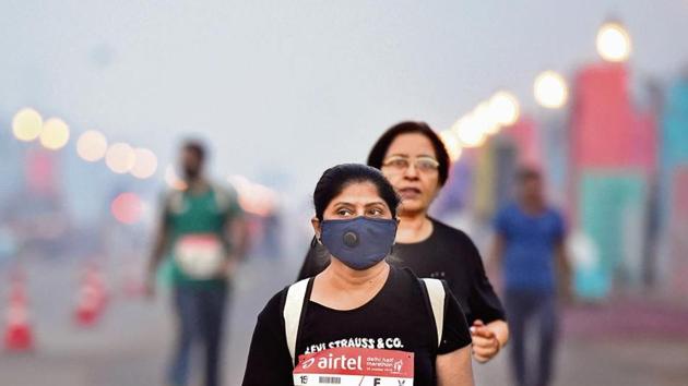 A participant seen wearing a pollution mask for protection against air pollution during the Delhi Half Marathon, near India Gate, in New Delhi, on Sunday. (Photo by Arvind Yadav/ Hindustan Times)