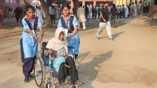 Volunteers assist a differently-abled voter to cast their vote at a polling station at Badkal in Faridabad, Haryana. As many as 1,169 candidates including 105 women of various political parties are contesting the election. Prominent figures include Manohar Lal Khattar, Bhupinder Singh Hooda, JJP’s Dushyant Chautala and INLD’s Abhay Singh Chautala. (PTI)