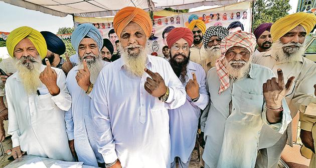 Voters show their inked fingers at a village in Dakha on Monday.(HT PHOTO)