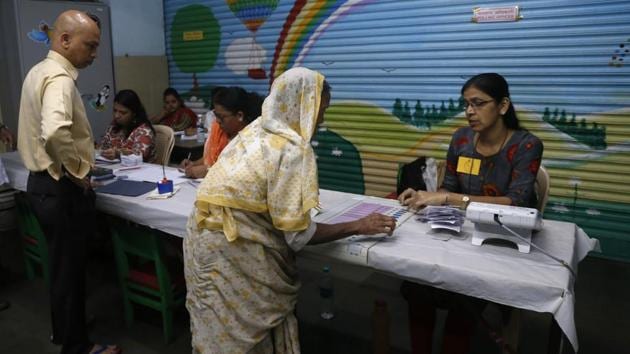 A polling officer explains voting procedure to an elderly woman at a polling station in Mumbai. Voter turnout for Maharashtra stood at 30.89% till 1 pm. Out of the 288 Assembly constituencies in the state, Armori witnessed the highest voter turnout of 52.89% and Ulhasnagar witnessed the lowest at 15.7% till 1 pm. (Rafiq Maqbool / AP )