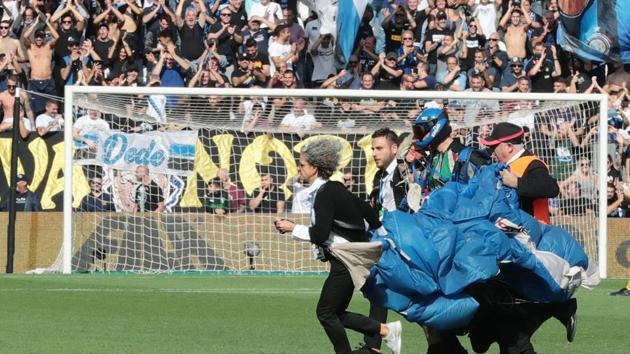 A parachutist who landed on the pitch during a Serie A match.(AP) A parachutist who landed on the pitch during a Serie A match.(AP)