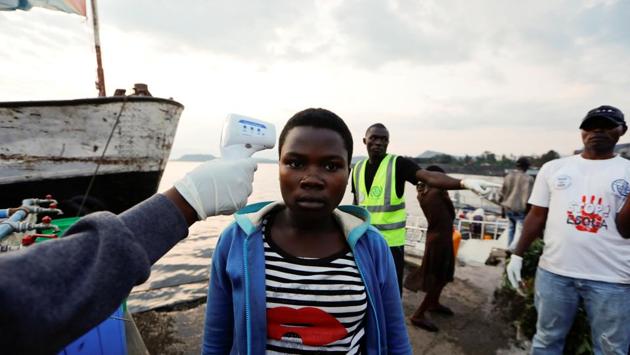 Mike Ndinga, 25, a health worker, directs people as his colleague checks the temperature of a citizen as part of the Ebola screening procedure upon her arrival, to the North of Lake Kivu. Mistrust and armed attacks against medical staff have slowed efforts to stamp out the epidemic. Even so, health authorities say survivors play a vital role in their communities by showing that Ebola can be overcome. (Zohra Bensemra / REUTERS)