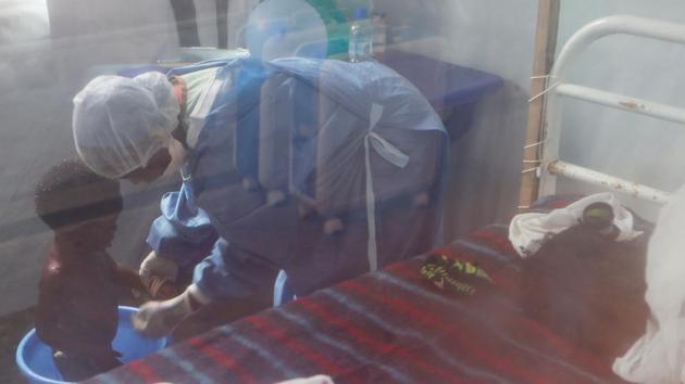 In Katwa, Noella Masika, wearing blue scrubs, a surgical mask and a hair net, bathed a 1-year-old girl suspected of having Ebola in a small plastic bucket. Masika lost 17 family members to Ebola, including both parents and two grandparents, but counts herself fortunate to have survived. “I feel compassionate and grateful for the care I received,” she said. “I feel an obligation to contribute to the fight against Ebola.” (Zohra Bensemra / REUTERS)