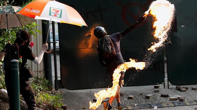 Anti-government demonstrators throws petrol bombs at a police station in Hong Kong. The protests were initially sparked by a now-shelved extradition law, but have morphed into calls for greater democracy and police accountability. Violence on both sides has escalated, with police firing live rounds and hardcore protesters wielding petrol bombs and rocks. (Tyrone Siu / REUTERS)