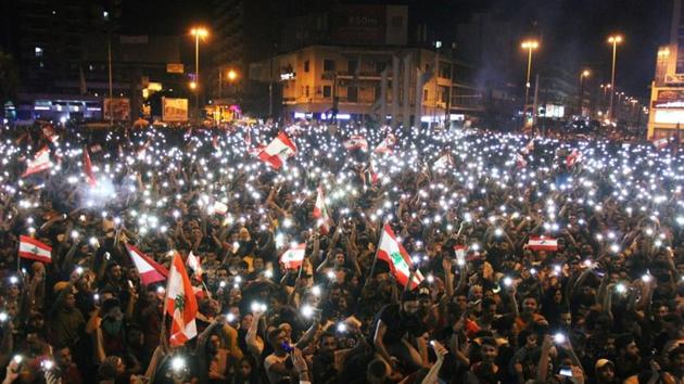 Demonstrators take part in an anti-government protest in Tripoli, Lebanon on Sunday. Euphoric crowds partied deep into the night Sunday, leaving political and sectarian paraphernalia at home to gather under the cedar-stamped national flag, dance to impromptu concerts and chant often hilarious anti-establishment slogans. (Omar Ibrahim / REUTERS)
