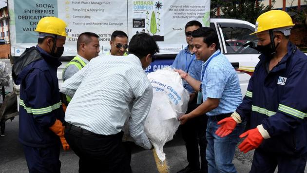 Nepal Yeti Airlines and Tara Air officials hand over waste collected from the Everest region to Blue Waste to Value workers. “We received a mix of materials from Everest -- aluminium, glass, plastic, iron -- much of which could be recycled,” Maharjan explained, adding: “We need to up-cycle and add value to them.” (Prakash Mathema / AFP)