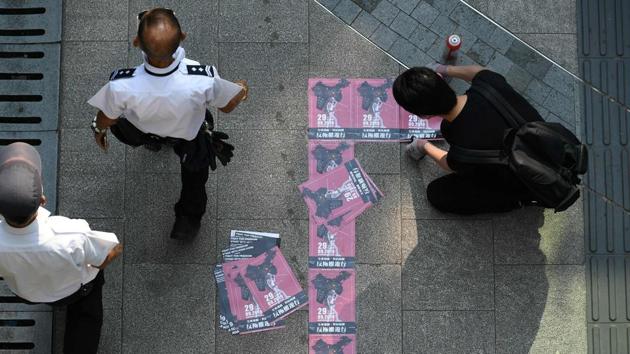 A man (R) sticks protest flyers onto the pavement of a pedestrian walkway at Victoria Park. Over the last four months of pro-democracy rallies, the areas where domestic workers rest on Sundays have frequently become battlegrounds. “This is not good. Hong Kong people also suffered,” Jochel said, adding that black-clad protesters helped her wash her eyes with saline solution and lead her to safety. (Mohd Rasfan / AFP)