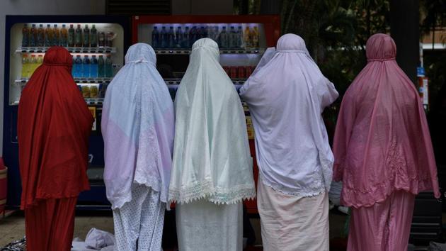 Indonesian migrant workers praying at Victoria Park in Hong Kong. Domestic workers earn a minimum of HK$4,630 (US$590) a month and must live with their employers in Hong Kong’s notoriously small flats. Rights groups have long complained that they are easily exploited by unscrupulous employers and hiring agents. (Mohd Rasfan / AFP)