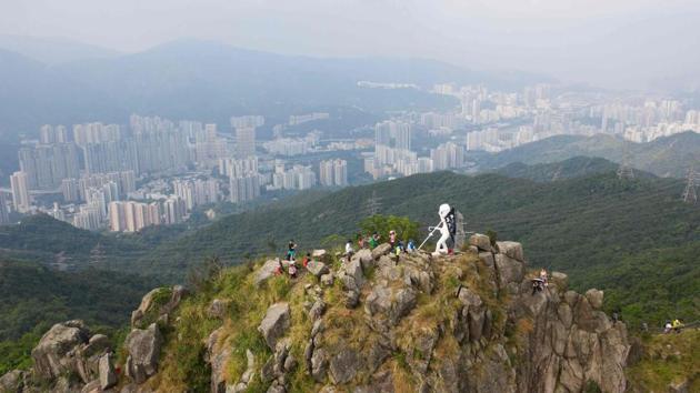 A four-metre statue known as Lady Liberty (C), after it was hauled by pro-democracy protesters to the top of Lion Rock, one of the Hong Kong’s most famous mountain tops. Sandy, an Indonesian worker, said she would often go hiking with friends on the trails that criss-cross Hong Kong. But now she tends to stay closer to her employer’s home, fearful that the weekend clashes will disrupt transport and leave her stranded. (Anthony Wallace / AFP)