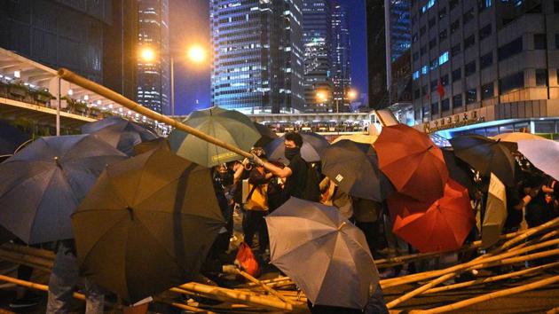 Protesters set up barricades as they gather in the Central district in Hong Kong. “If we go too far away, we worry that we can’t go home. We have a duty to be home at 10 or 9 pm,” Sandy told AFP. “We try to stay away for our own safety,” she added, recalling how she first encountered tear gas when she was stuck between demonstrators and police in Central and there were no subway services. (Philip Fong / AFP)