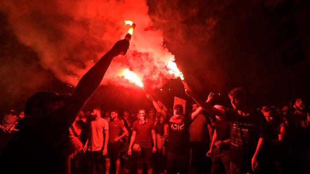 Lebanese protesters burn flares during demonstrations on Monday at Riad al-Solh Square in Beirut. Hundreds of thousands of people have flooded the streets since Thursday, furious at a political class they accuse of pushing the economy to the point of collapse. Roads were blocked for a fifth day across the country. Schools, banks and businesses were closed, and Banks are expected to remain shut on Tuesday. (Anwar Amro / AFP)