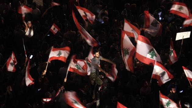 Anti-government protesters in Beirut on Monday. The number of protesters swelled following the Cabinet announcement amid intense scepticism that the reforms amounted to anything serious. They included many young men and women as well as whole families, with children waving the national red and white flag with a cedar tree in the centre. (Hassan Ammar / AP)
