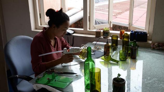 A worker uses a glue gun as she recycles a bottle. “When they see these kind of products they are like ‘wow’, these things can be made and it is possible,” Lepcha explained. Their products are now used in upmarket hotels, restaurants, and homes around the capital, and Lepcha says there is growing consumer interest in goods made from salvaged Everest scraps. (Prakash Mathema / AFP)