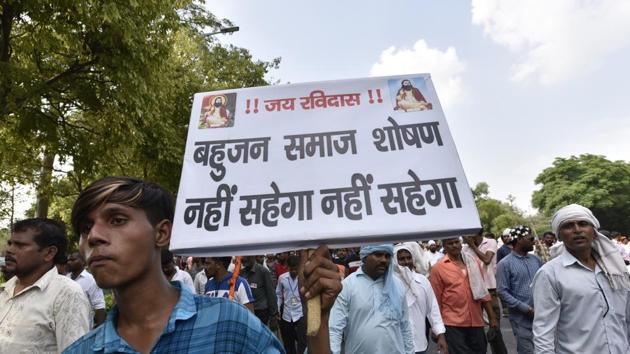 A man holds a placard during a protest against the demolition of Sant Ravidas Temple in New Delhi in August.(Sanjeev Verma/HT PHOTO)