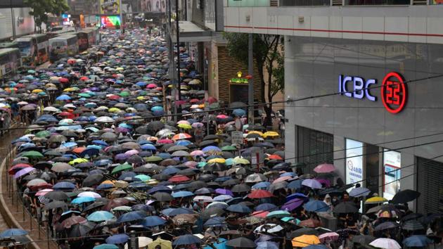 People take part in a rainy protest march from the Causeway Bay shopping district. The workers are only entitled to one day off a week and most take Sundays. On their day off, Indonesian workers traditionally flock to the Causeway Bay district, while Filipinos tend to gather in nearby Central and Admiralty. All three have become frequent flashpoints this summer. (Nicolas Asfouri / AFP)