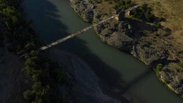 An old bridge spans the Vjosa River near the border with Greece, in Albania. Vjosa runs for more than 270 kilometers in its course through the forest-covered slopes of Greece’s Pindus mountains to Albania’s Adriatic coast, changing its hues along the way. The government intends to build eight dams along the main river, but residents are challenging the move. (Felipe Dana / AP)