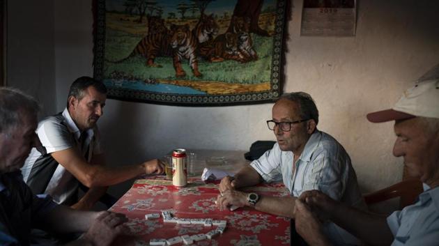Residents play dominoes in a small bar in the village of Kute, Albania. Dozens of residents from the village joined nonprofit organizations to file what was Albania's first environmental lawsuit against the construction of a dam in the Pocem gorge. They won in 2017, but the government has appealed. Relieved by their victory, they now wait anxiously for the outcome of the government’s appeal. (Felipe Dana / AP)