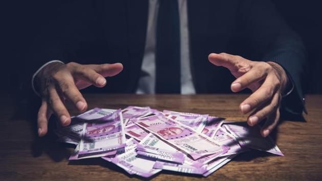 Businessman taking pile of money, Indian Rupee banknotes, on his desk in a dark office - corruption concept (Getty Images/iStockphoto) Businessman taking pile of money, Indian Rupee banknotes, on his desk in a dark office - corruption concept (Getty Images/iStockphoto)