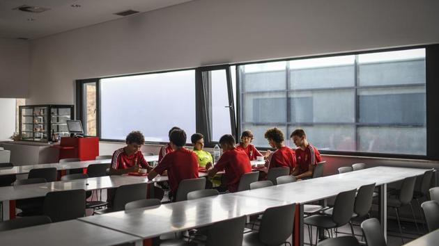 The players sit down for a meal. While the Portuguese team that won Euro 2016 was largely made up of players from Sporting’s youth system, today it is the youngsters brought through by Benfica that dominate the national set-up. This season, the squad includes eight players from the school, including Portuguese internationals Ruben Dias and Gedson Fernandes, as well as up-and-comers like Florentino Luis, Ferro and Jota. (Patricia De Melo Moreira / AFP)
