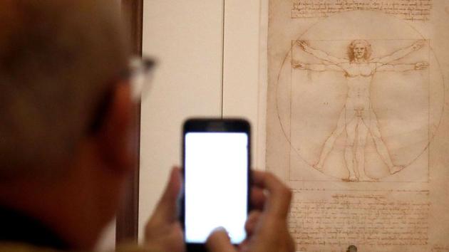 A man looks at the “Vitruvian Man” the famous annotated drawing, made around 1490 with pen, ink and wash on paper by Leonardo, during the show. The drawing -- which Italian media say is insured for at least one billion euros -- joined the Louvre show with just days to spare before the opening. It will stay only eight weeks rather than the full four months of the show. (Francois Guillot / AFP) A man looks at the “Vitruvian Man” the famous annotated drawing, made around 1490 with pen, ink and wash on paper by Leonardo, during the show. The drawing -- which Italian media say is insured for at least one billion euros -- joined the Louvre show with just days to spare before the opening. It will stay only eight weeks rather than the full four months of the show. (Francois Guillot / AFP)