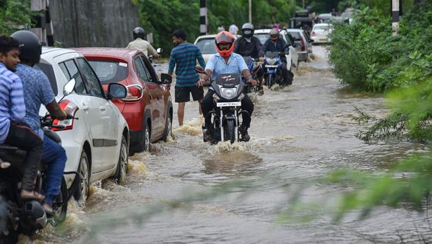 Commuters wade across a waterlogged road in Visakhapatnam on Wednesday following heavy rain. (PTI) Commuters wade across a waterlogged road in Visakhapatnam on Wednesday following heavy rain. (PTI)