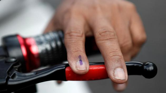 A man's inked marked finger is seen as he leaves a polling station on his bike after casting his vote during Maharashtra state elections in Mumbai.(Photo: Reuters)