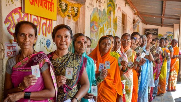 Woman voters display their identity cards as they wait in a queue to cast their votes for Maharashtra Assembly polls, in Sangli, Monday.(PTI)