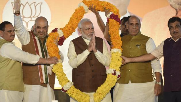Prime Minister Narendra Modi is garlanded as he arrives to addresses his supporters after Haryana and Maharashtra election results were declared at party headquarters in New Delhi on Thursday, October 24.(Burhaan Kinu/HT PHOTO)