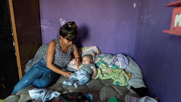 Luli, 19, plays with her son at her home in Villa 31. Luli has gone through a year of treatment since contracting the disease while she was pregnant. She says her baby luckily did not get infected. She lives in a flat with one bedroom, a kitchen and no bathroom, with her son and partner. "We are constantly moving from one house to another because of the high price of the rent," she said. (Magali Druscovich / REUTERS) Luli, 19, plays with her son at her home in Villa 31. Luli has gone through a year of treatment since contracting the disease while she was pregnant. She says her baby luckily did not get infected. She lives in a flat with one bedroom, a kitchen and no bathroom, with her son and partner. "We are constantly moving from one house to another because of the high price of the rent," she said. (Magali Druscovich / REUTERS)