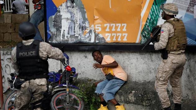 A man reacts in front of Haitian National Police (PNH) officers during clashes with protesters marching to demand the resignation of Haitian President Jovenel Moise, in the streets of Petion Ville, Port-au-Prince, Haiti. (Andres Martinez Casares / REUTERS)