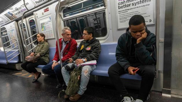 Richard McLachlan speaks with subway rider Anthony Urias. McLachlan estimates that thousands of passengers have heard his talk. Some days he delivers it up to six times, but never in front of young children. “Talking about the end of the world in front of a subway car full of five-year-olds just doesn’t feel comfortable,” he explained. (Don Emmert / AFP)