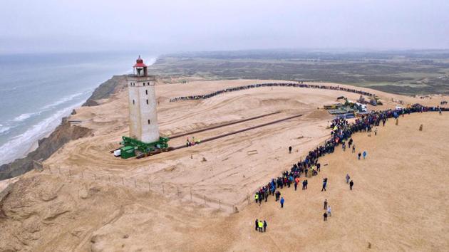 People look on as the lighthouse in Rubjerg Knude is being moved away from the coastline between Lonstrup and Lokken, Jutland, Denmark. The 120-year-old lighthouse was put on wheels and rails to attempt to move it some 80 metres away from the North Sea which has been eroding the coast leaving the lighthouse about 6 meters away from the shoreline. (Hans Ravn / Ritzau Scanpix / AFP)