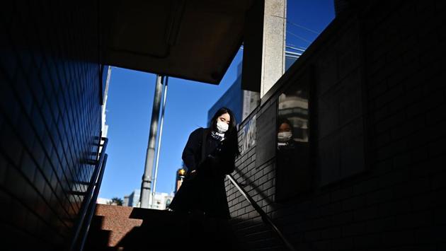 A woman walks down the stairs of a train station in Tokyo’s Ginza. (Charly Triballeau / AFP)