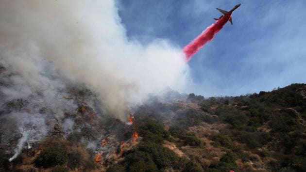 A firefighting aircraft drops fire retardant Phos-Chek in the Pacific Palisades neighbourhood. New evacuations were ordered early Friday as the fire continued to spread, driven by so-called Santa Ana winds gusting up to 105 kilometers per hour. Some 1,325 firefighters backed by air tankers and helicopters were battling the flames that raced toward densely packed communities and threatened 10,000 structures. (Mario Tama / Getty Images / AFP) A firefighting aircraft drops fire retardant Phos-Chek in the Pacific Palisades neighbourhood. New evacuations were ordered early Friday as the fire continued to spread, driven by so-called Santa Ana winds gusting up to 105 kilometers per hour. Some 1,325 firefighters backed by air tankers and helicopters were battling the flames that raced toward densely packed communities and threatened 10,000 structures. (Mario Tama / Getty Images / AFP)