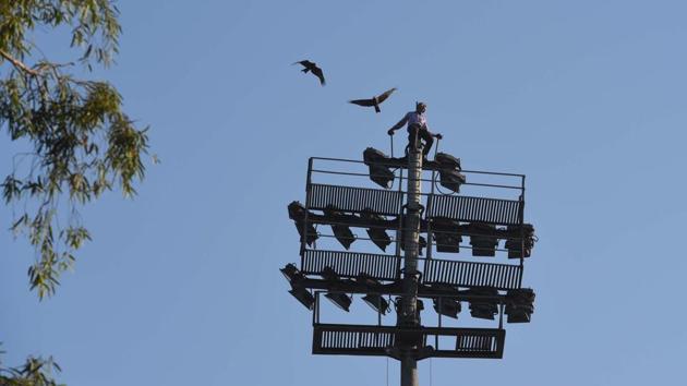Joshi Singh, 50, a peon at Chatrasal Stadium is seen on top of a High Mast light that he climbed in protest for not receiving his salary for the last 22 months, at Chatrasal Stadium, in New Delhi. (Sanchit Khanna / HT Photo) Joshi Singh, 50, a peon at Chatrasal Stadium is seen on top of a High Mast light that he climbed in protest for not receiving his salary for the last 22 months, at Chatrasal Stadium, in New Delhi. (Sanchit Khanna / HT Photo)