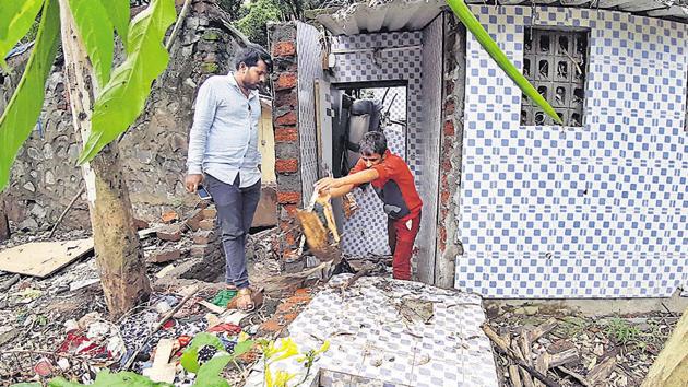 Residents of Tangewala Colony which was the worst affected area clean their houses as incessant rains continue in city.(Rahul Raut/HT PHOTO)