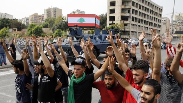 Anti-government protesters raise their hands as police disperse them from main highway in Beirut, Lebanon, Saturday, Oct. 26, 2019. The removal of the roadblocks on Saturday comes on the tenth day of protests in which protesters have called for civil disobedience until the government steps down. (AP Photo/Bilal Hussein)(AP)
