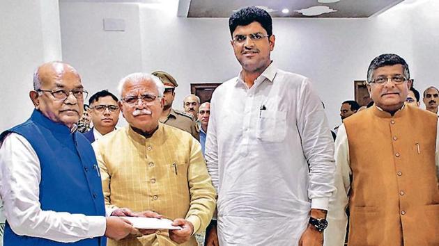 (L-R) Haryana governor Satyadeo Narain Arya, chief minister-designate Manohar Lal Khattar, JJP chief Dushyant Chautala at the Raj Bhawan in Chandigarh on Saturday. (PTI Photo) (L-R) Haryana governor Satyadeo Narain Arya, chief minister-designate Manohar Lal Khattar, JJP chief Dushyant Chautala at the Raj Bhawan in Chandigarh on Saturday. (PTI Photo)