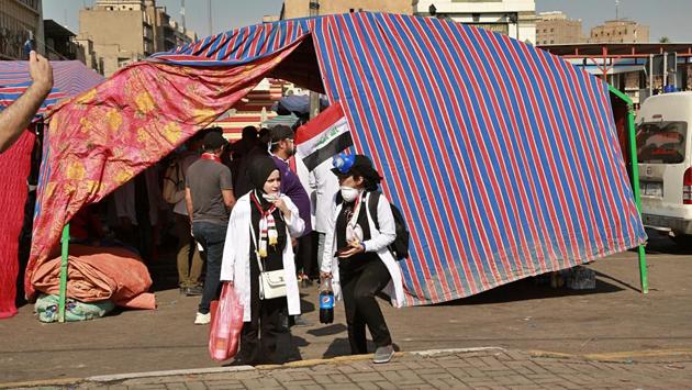 Large tents had been set up and volunteers were distributing food and water to demonstrators. Two elderly women in traditional black robes and head scarves hopped up on a concrete barrier and waved the Iraqi flag. “I’m here for the generation that’s coming,” said one young woman who identified herself as a prenatal nurse. “Our generation is psychologically tired, but it’s alright as long as this is for the next one,” she said. (Hadi Mizban / AP)
