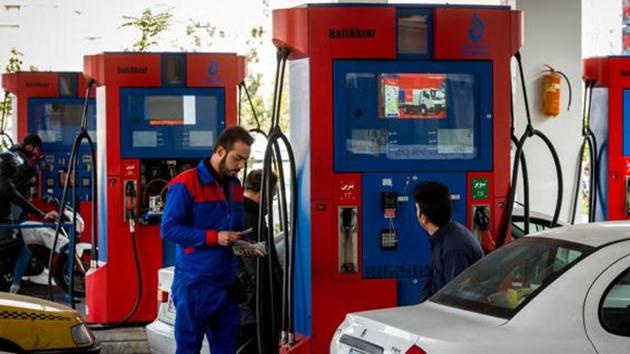 An attendant checks banknotes at a Petroayric gas station in Tehran, Iran.(Bloomberg photo)