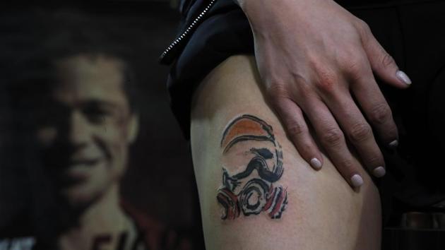 A woman who goes by the single name "Mary" receiving a tattoo of a Hong Kong protester clad in protective gear.(AP photo)