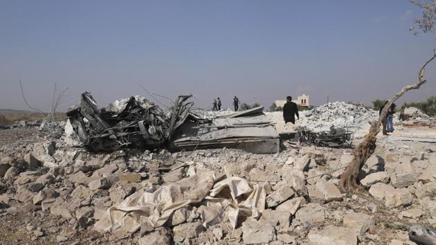 People look at a destroyed houses near the village of Barisha, in Idlib province, after an operation by the U.S. military which targeted Abu Bakr al-Baghdadi, the shadowy leader of the Islamic State.(AP photo)
