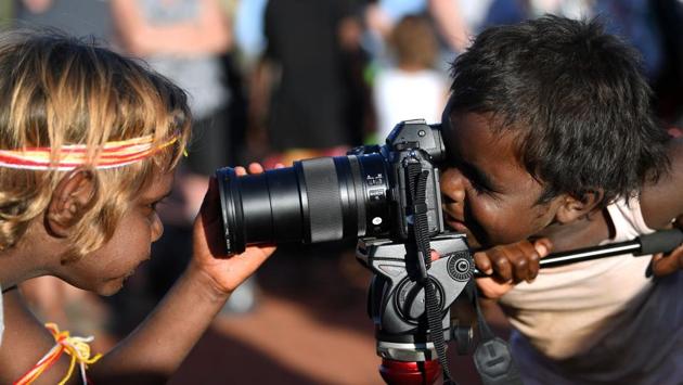 Anangu children play with a camera during the ceremony. Parks Australia added extra rangers on patrol over the weekend, with fines for those who attempt to summit the rock now reaching up to Aus$10,000 ($6,800). “Although we expect our visitors to respect the law and the wishes of traditional owners when they visit, significant penalties can be issued,” Parks Australia told national broadcaster ABC. (Saeed Khan / AFP)