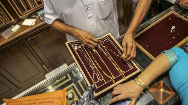 An employee shows gold necklaces to a customer. “What is keeping the buyers away are the high prices and the slowdown in the economy,” Padmanaban said by phone. “People have their savings, but they are safeguarding it for the future as they don’t know what is in store for the next two to three months. So the fear is holding them back from spending.” (Dhiraj Singh / Bloomberg)
